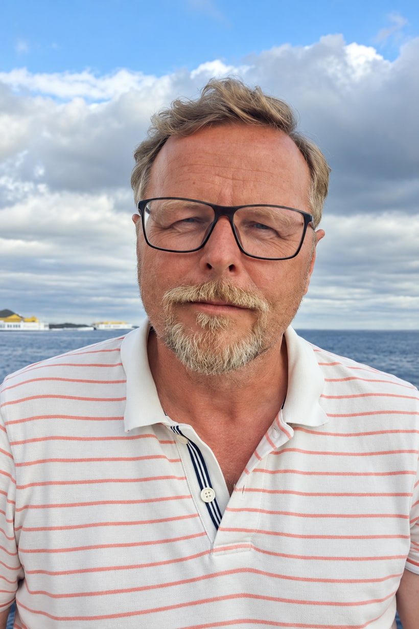 Peter im weiß-orange gestreiften Poloshirt vor dem Wasser